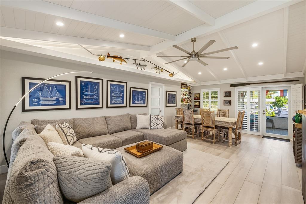 A living and dining area with a sectional sofa, vaulted ceilings, and nautical wall art — 19154 NEW HAVEN COURT, PORT CHARLOTTE, FL
