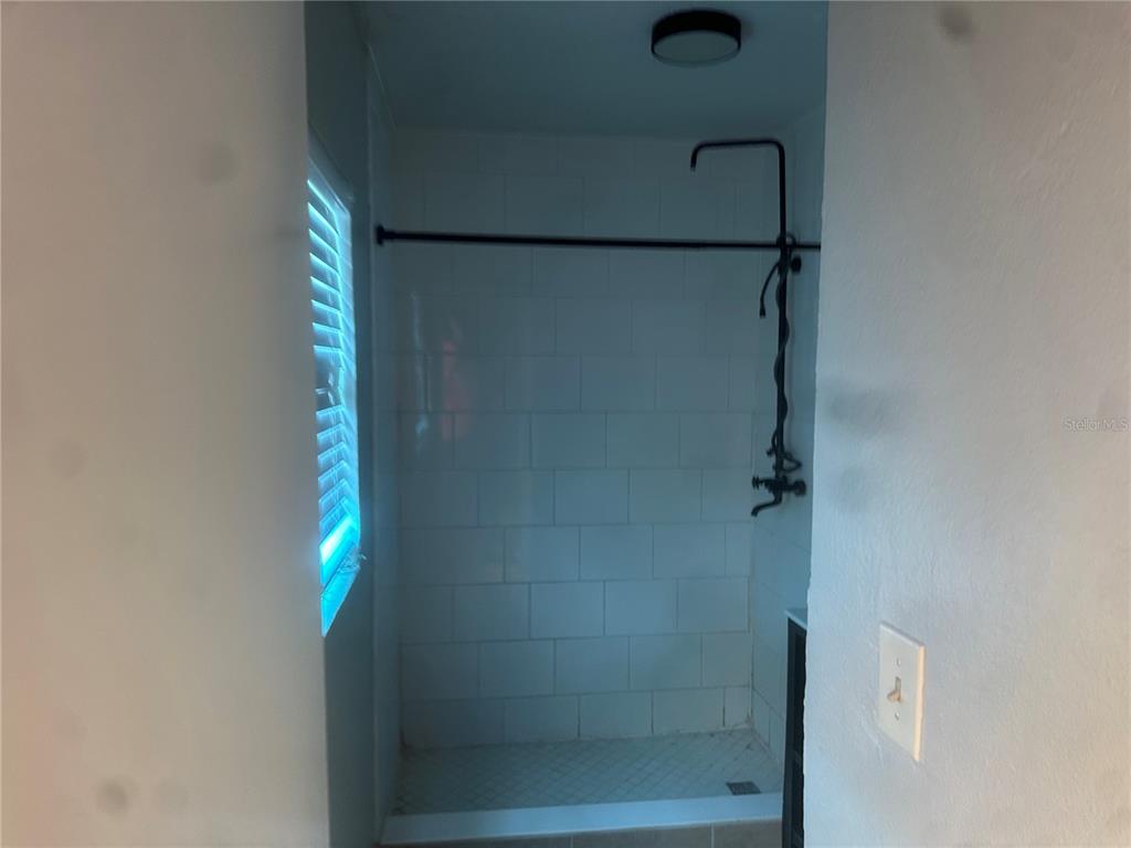 A walk-in shower features white subway tile walls, a black shower fixture, and a window — 330 20TH AVENUE S UNIT LOWER, ST PETERSBURG, FL