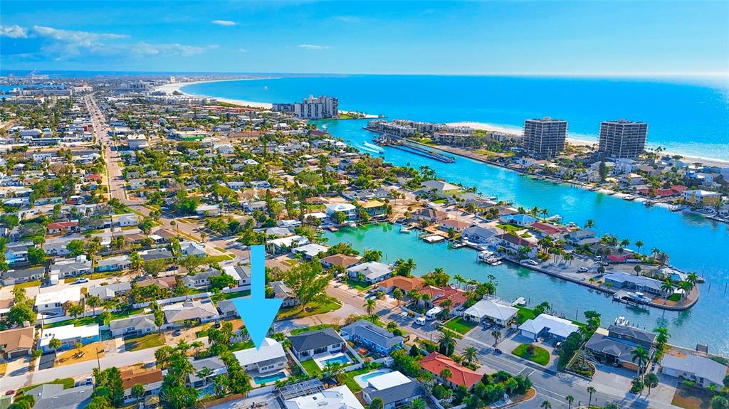 An aerial view shows a residential neighborhood with a canal and a beach nearby — 455 81ST AVENUE, ST PETE BEACH, FL