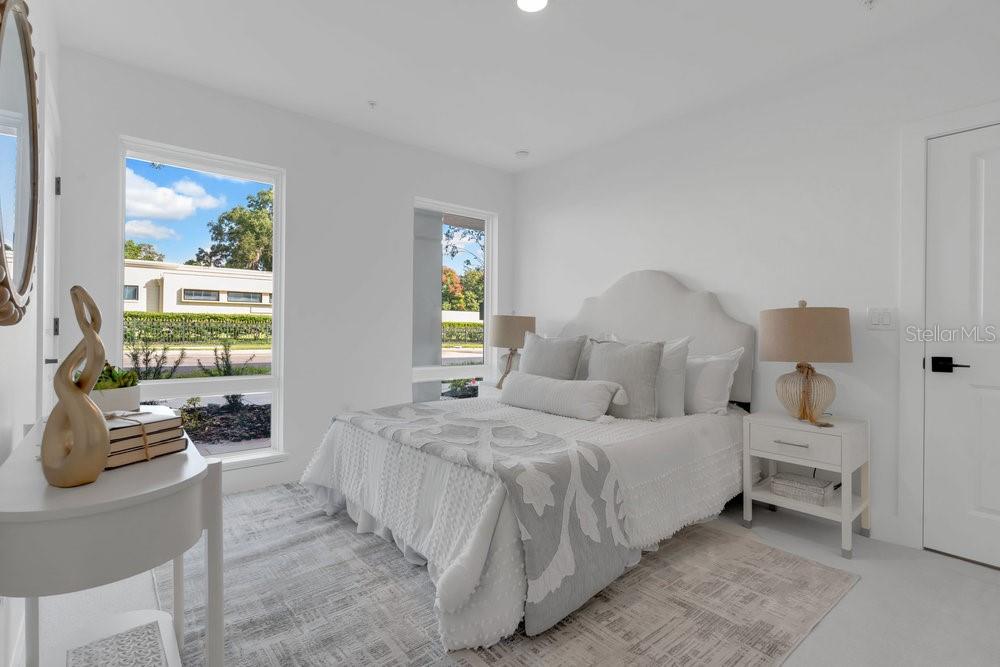 A bright bedroom features a queen bed, two windows, and a white nightstand — 1004 E ROBINSON, ORLANDO, FL