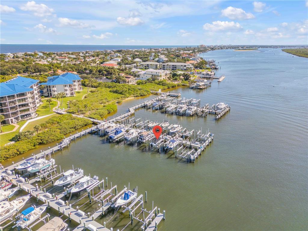 An aerial view shows a marina with multiple boat slips and docked boats on a waterway — 0 PENINSULA UNIT C35, NEW SMYRNA BEACH, FL
