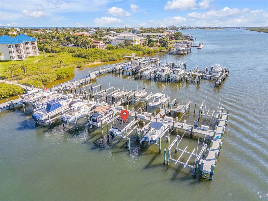 An aerial view shows a boat docked at a marina with a red location pin — 0 PENINSULA UNIT C35, NEW SMYRNA BEACH, FL