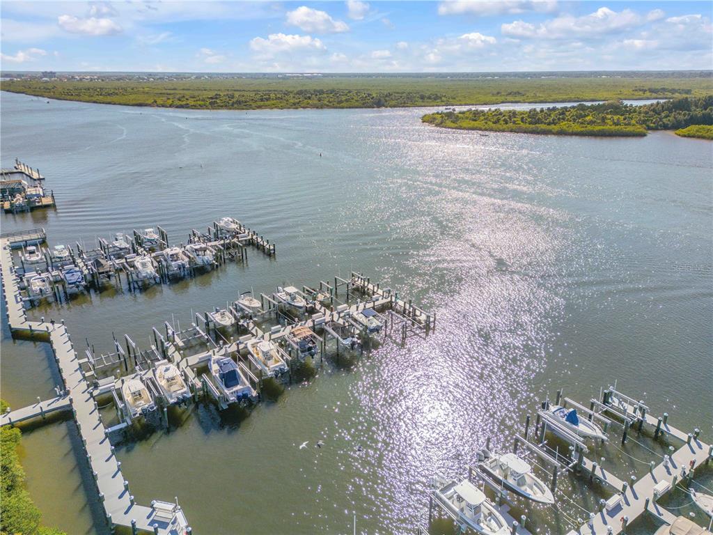 An aerial view shows a marina with numerous docked boats on a sunny day — 0 PENINSULA UNIT C35, NEW SMYRNA BEACH, FL