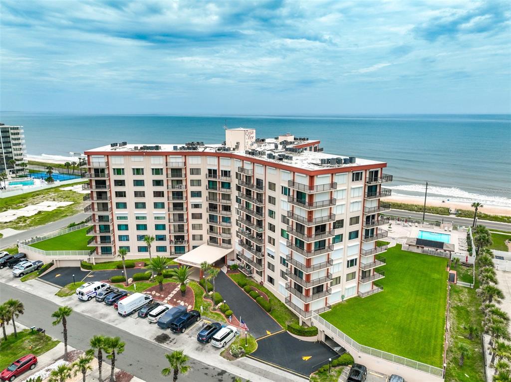 An aerial view of a multi-story beachfront apartment building with a parking lot and lawn — 3600 S OCEAN SHORE BOULEVARD UNIT 222, FLAGLER BEACH, FL
