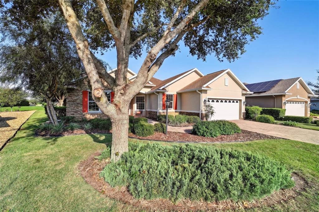 A single-story house exterior features stone veneer, red shutters, and a brick paver walkway — 8943 SW 86TH LOOP, OCALA, FL
