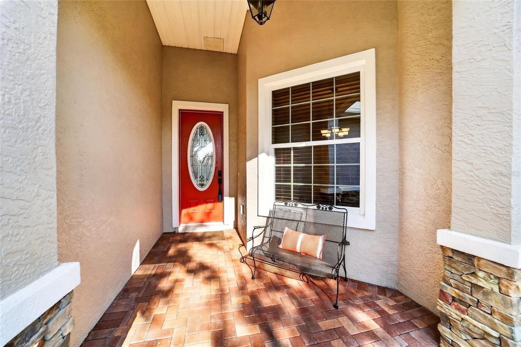 An entryway features tile flooring, a red patterned rug, a console table, and wall clocks — 8943 SW 86TH LOOP, OCALA, FL