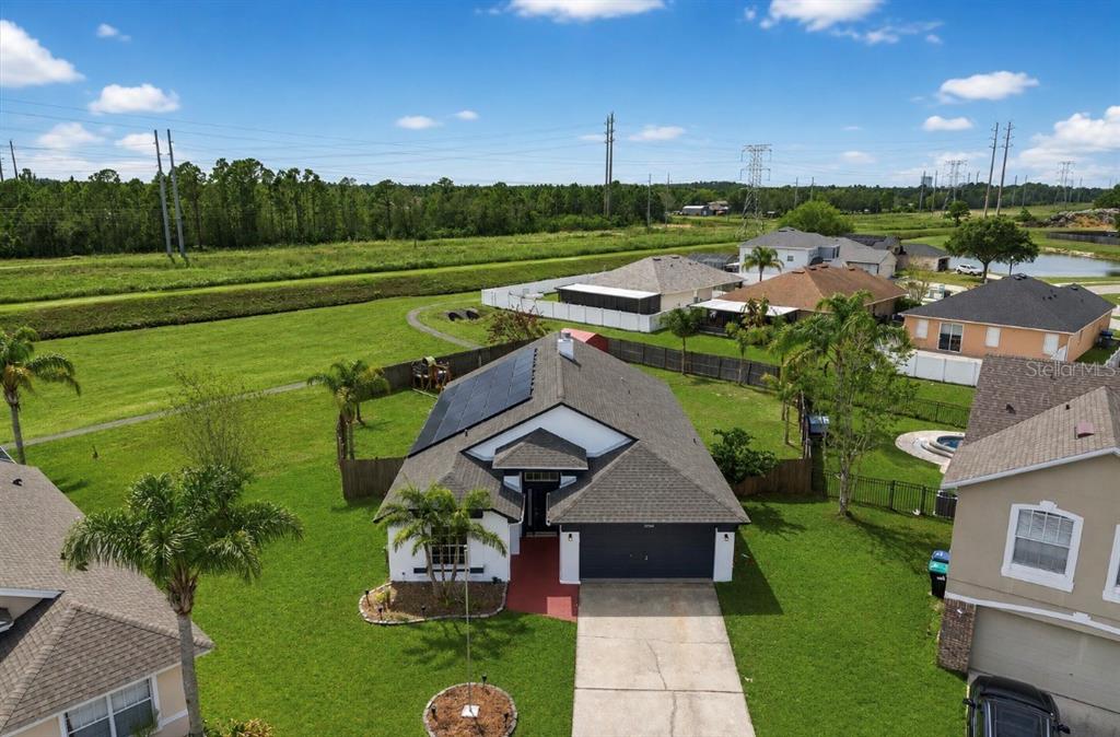 An aerial view shows a single-story house with solar panels and a driveway — 19500 GLEN ELM WAY, ORLANDO, FL