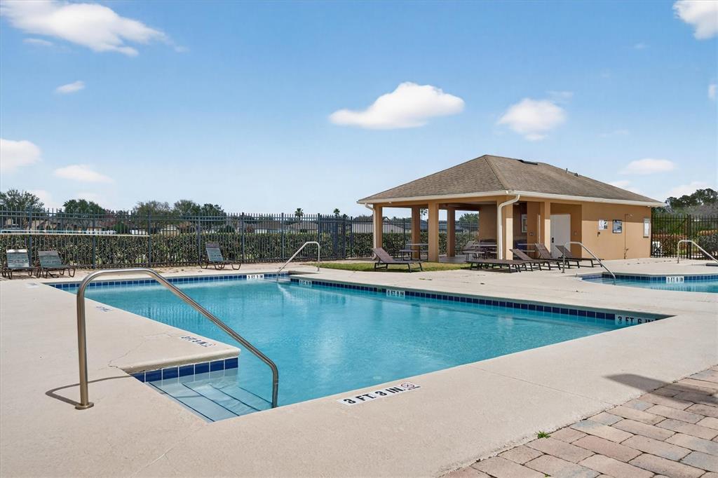 An outdoor swimming pool with a surrounding concrete deck and a nearby covered pavilion — 19500 GLEN ELM WAY, ORLANDO, FL