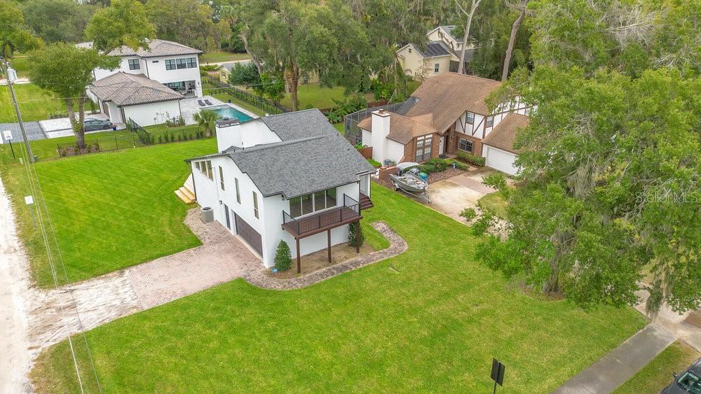 An aerial view shows a white two-story house with a dark roof and a balcony — 905 MAIN STREET, WINDERMERE, FL