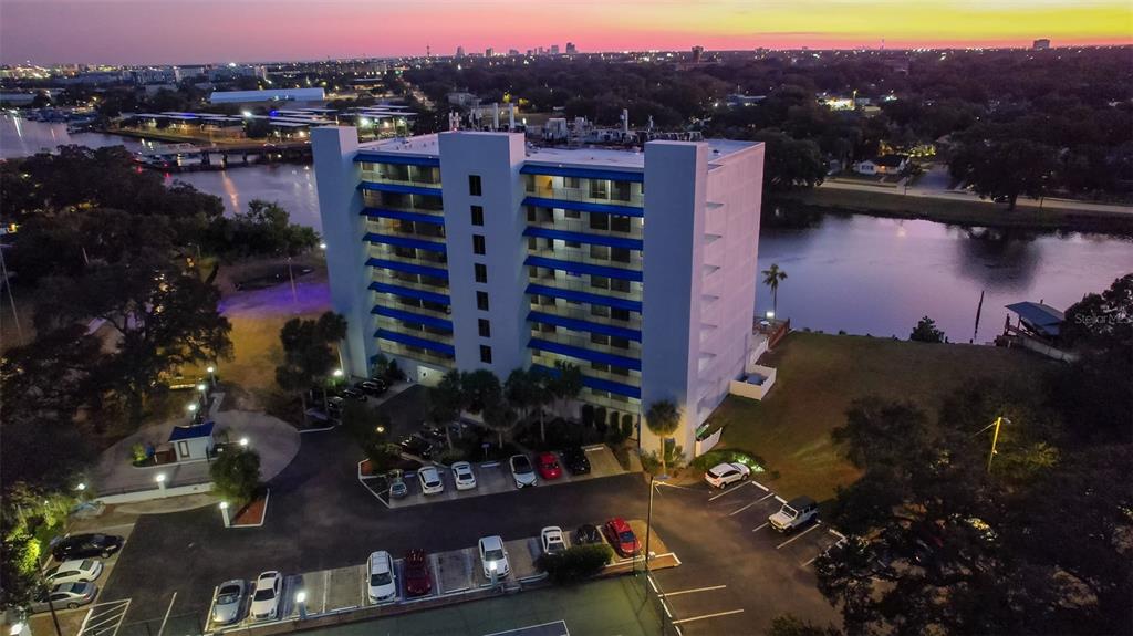 An aerial view of a multi-story apartment building situated next to a river at sunset — 2780 N RIVERSIDE DRIVE UNIT 805, TAMPA, FL