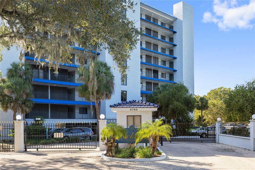 A multi-story apartment building stands behind a gated entrance with a security booth — 2780 N RIVERSIDE DRIVE UNIT 805, TAMPA, FL