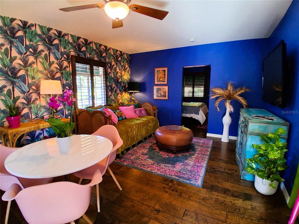 A living room features bold blue walls, tropical wallpaper, a daybed, and a dining set — 451 WOODLAND DRIVE, SARASOTA, FL