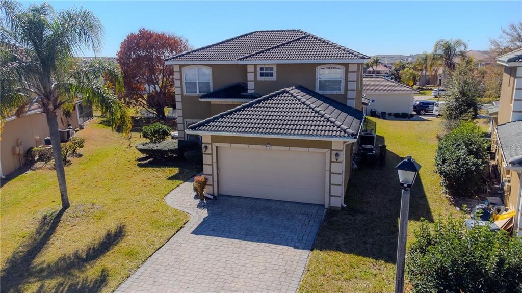 An aerial view of a two-story house with a tiled roof and a paved driveway — 416 VISTA LOOP, DAVENPORT, FL