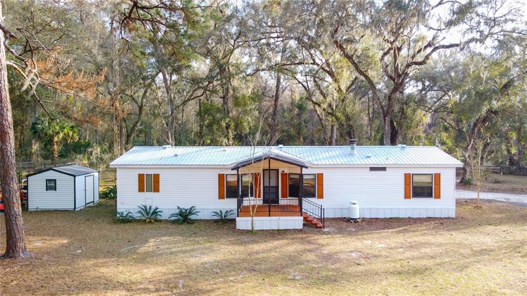 A single-story manufactured home with a metal roof and a small front porch — 1154 SE 95TH STREET, OCALA, FL