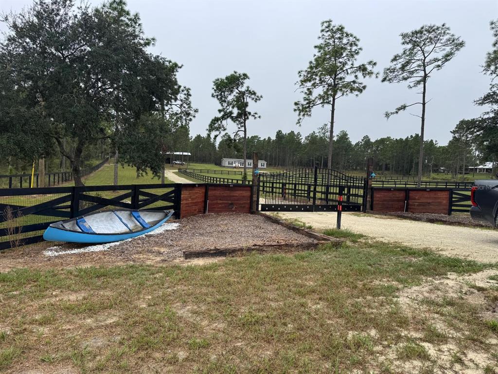 An aerial view shows a fenced pasture with a house and trees in the background — 14270 SE 60 STREET, MORRISTON, FL