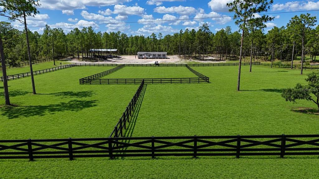 An aerial view of a single-story manufactured home situated on a cleared, sandy lot — 14270 SE 60 STREET, MORRISTON, FL
