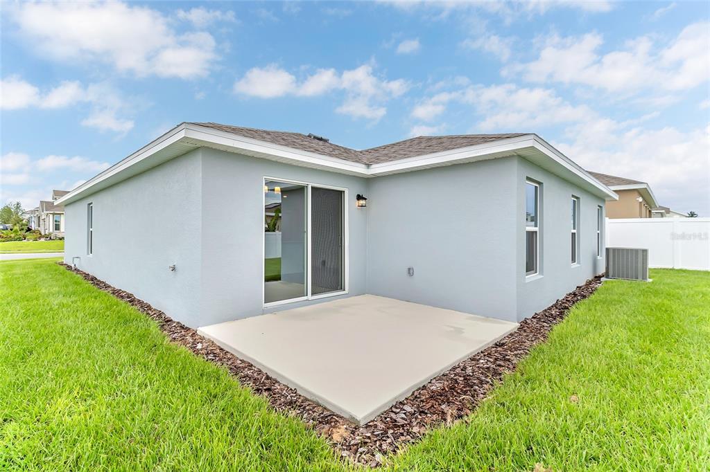 A kitchen with dark wood cabinets and a granite island overlooks an open living area — 123 BOTTLE BRUSH DRIVE, HAINES CITY, FL