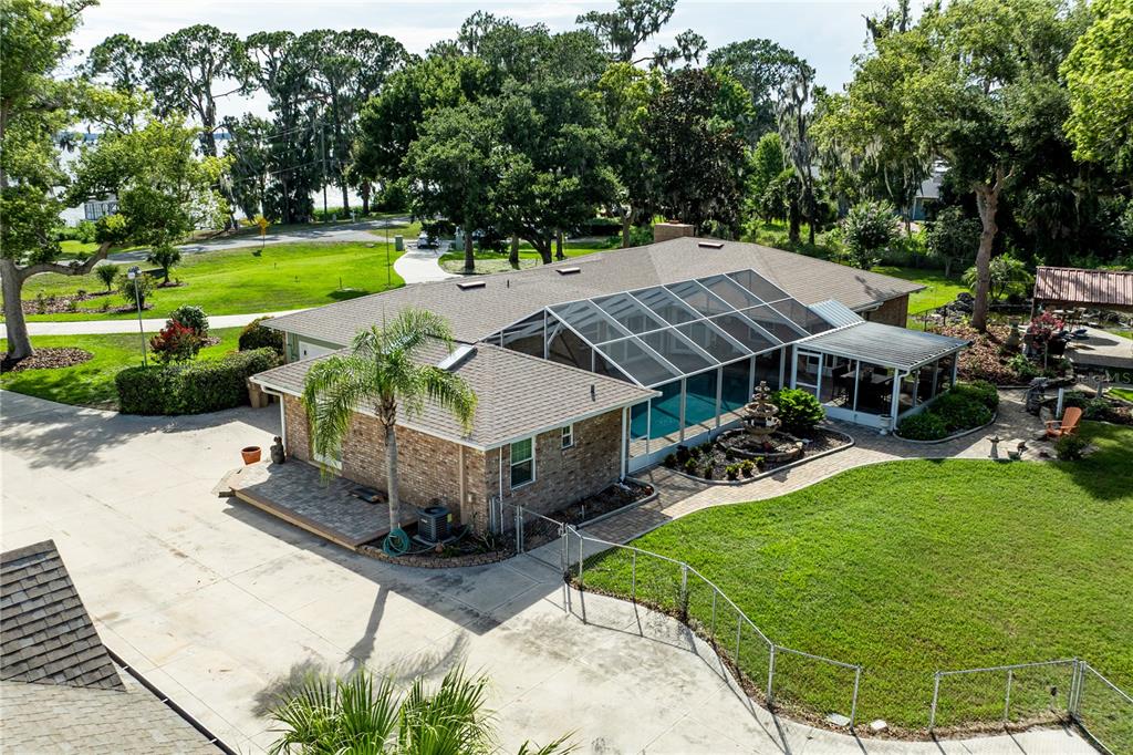 A wooden dock with a patio table and chairs overlooks a large lake — 32834 LAKESHORE DRIVE, TAVARES, FL