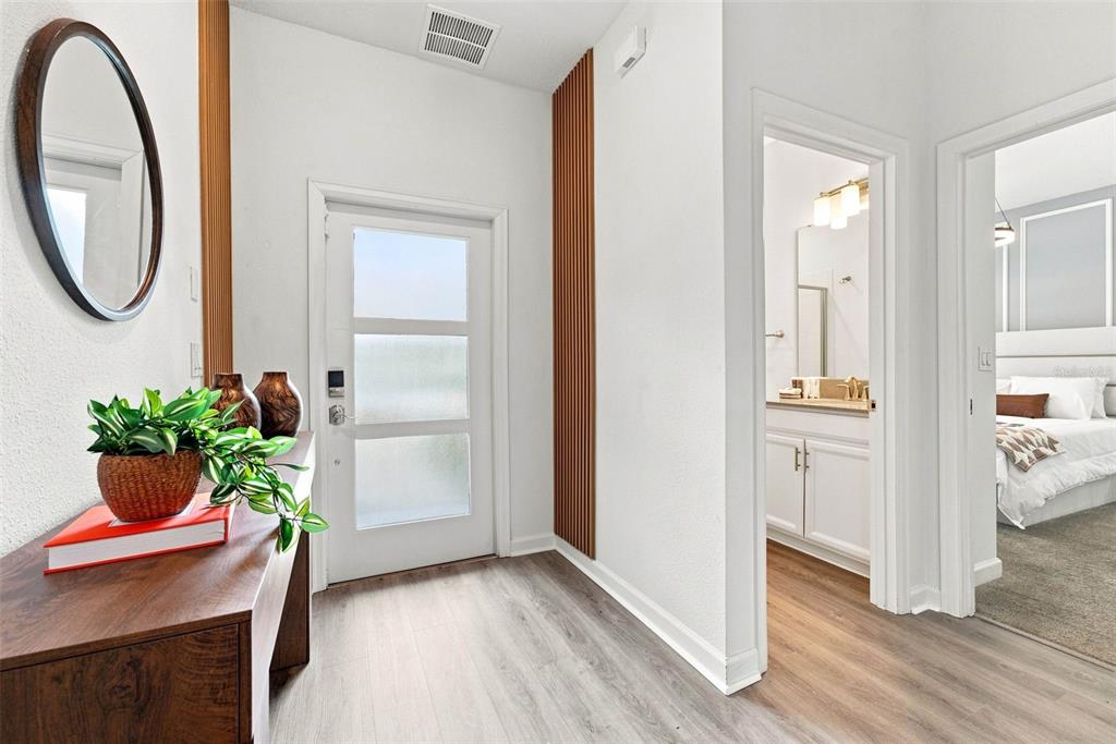 An entryway with wood-slat wall accents, a console table, and views into a bathroom and bedroom — 880 PEBBLE BEACH DRIVE, DAVENPORT, FL