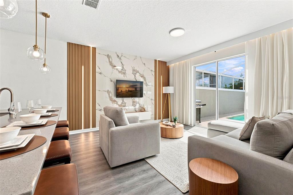 A living room features a marble accent wall, wood slat panels, and a sliding glass door — 880 PEBBLE BEACH DRIVE, DAVENPORT, FL