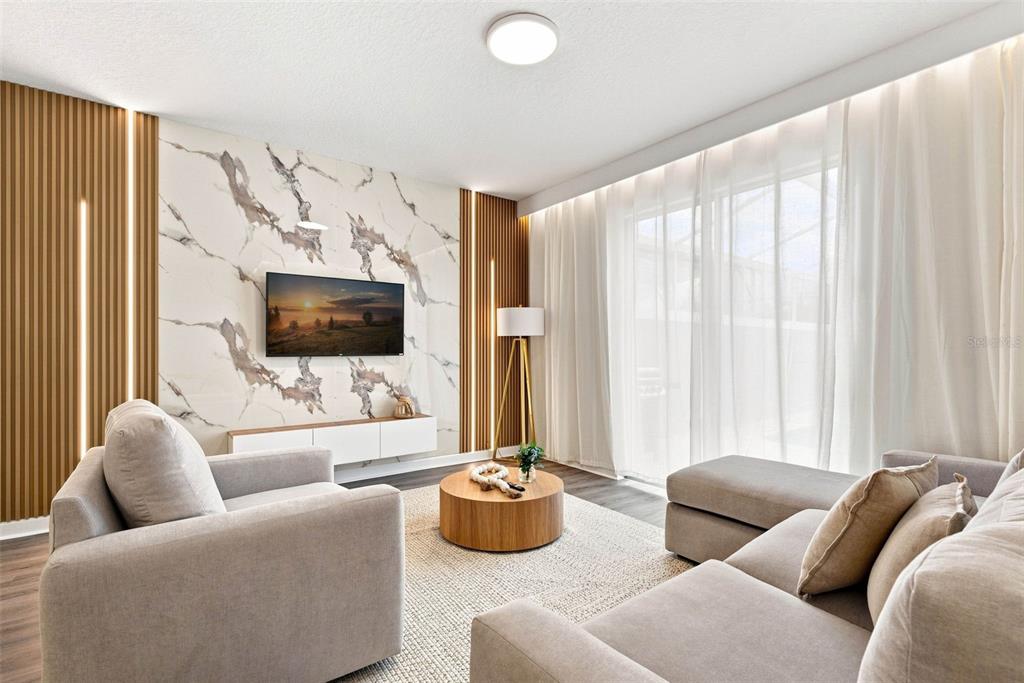 A modern living room features a marble accent wall, vertical wood slats, and neutral furniture — 880 PEBBLE BEACH DRIVE, DAVENPORT, FL