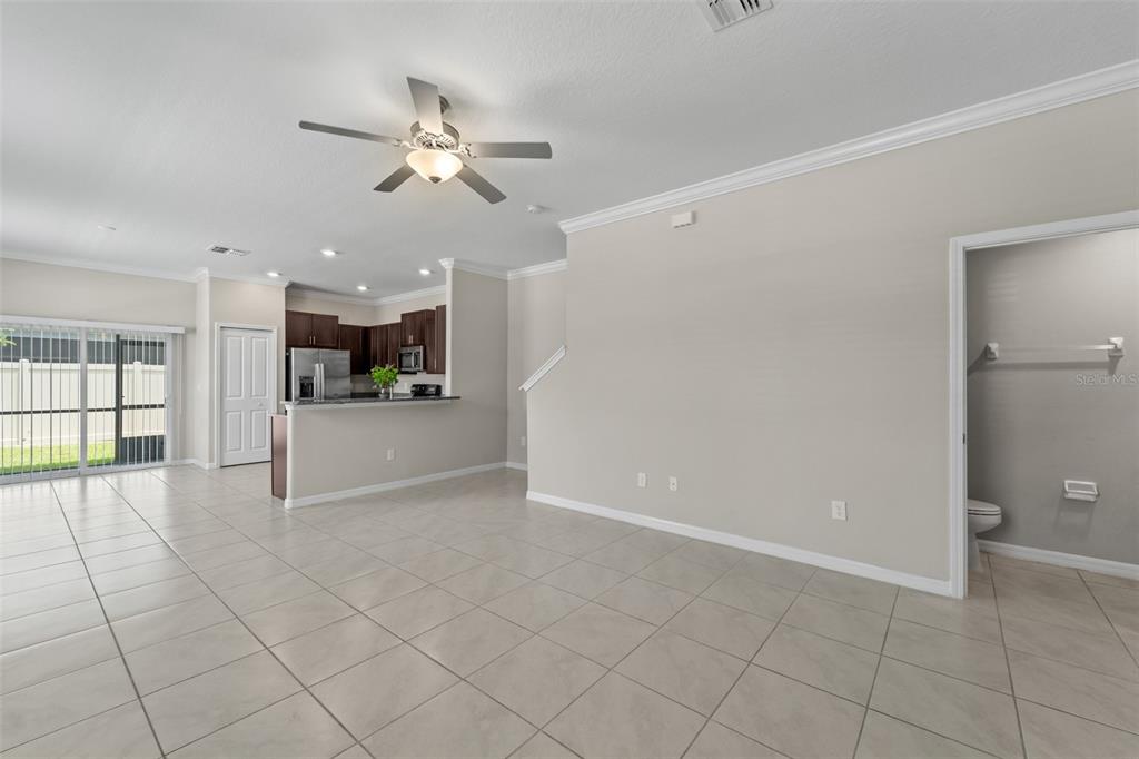 An open-concept living area features light tile flooring, a ceiling fan, and a kitchen island — 2188 CERULEAN SKY DRIVE, LUTZ, FL
