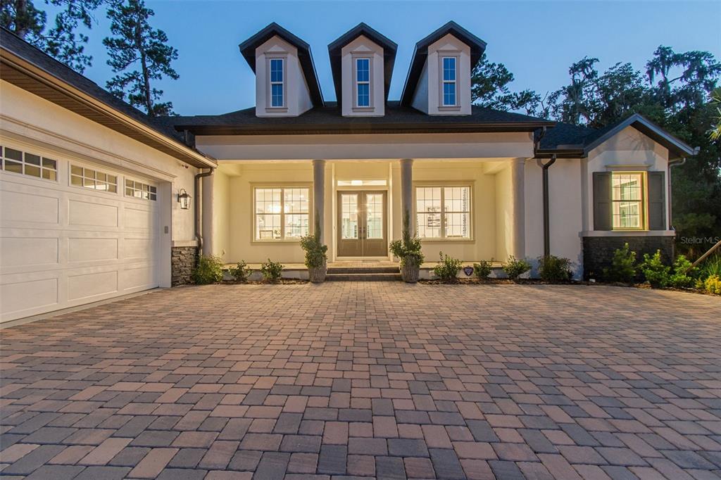 A single-story house exterior features a paved driveway, three dormer windows, and a covered entryway — 6470 SUMMIT VIEW DRIVE, BROOKSVILLE, FL