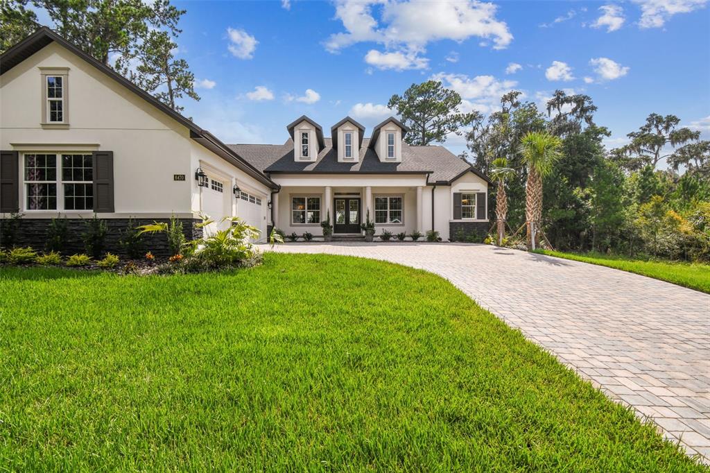 A single-story house with a white exterior, dark shutters, and a paved driveway — 6470 SUMMIT VIEW DRIVE, BROOKSVILLE, FL