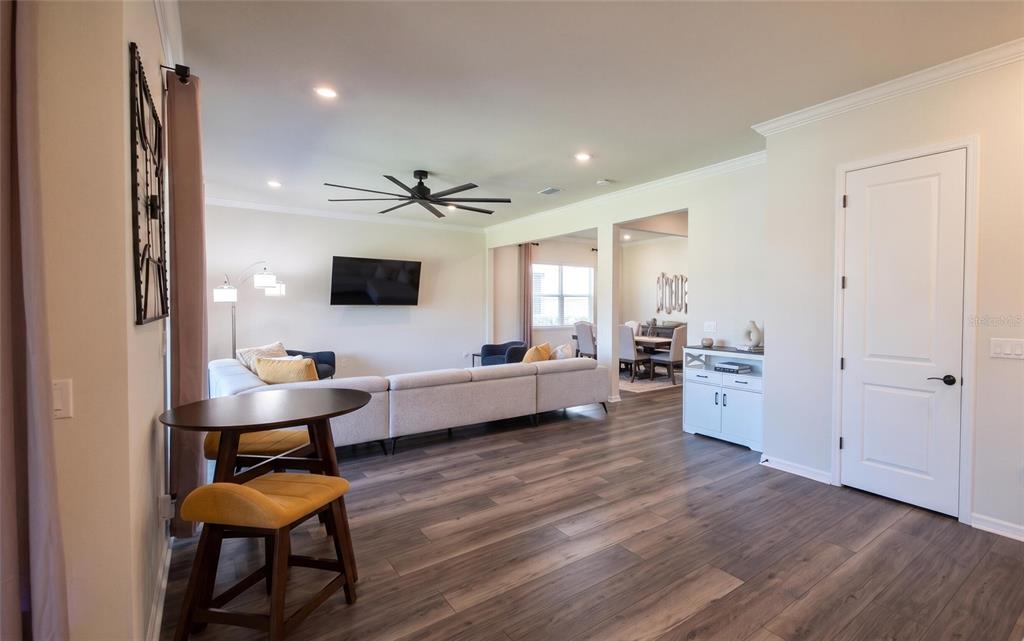 A modern kitchen features white cabinets, a dark blue island with bar stools, and dining area — 13360 PANAMA BEACH COURT, ORLANDO, FL