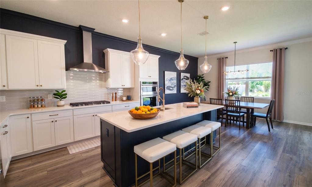 An open-concept living and dining area features wood-look flooring, recessed lighting, and a sliding door — 13360 PANAMA BEACH COURT, ORLANDO, FL