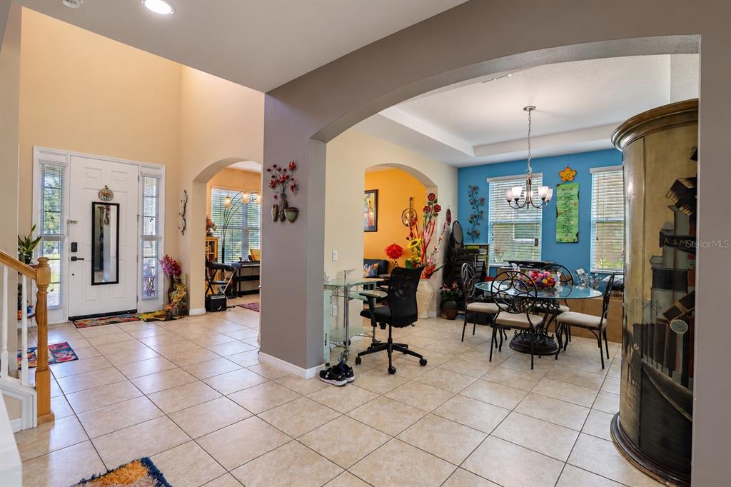 An entryway features tile flooring, a staircase with a wooden railing, and a front door — 4858 TERRA SOLE PLACE, ST CLOUD, FL