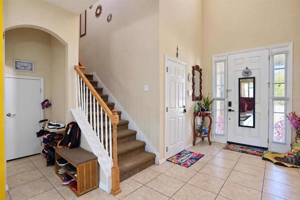 A bedroom features a light wood bed frame, a matching nightstand, and patterned bedding — 4858 TERRA SOLE PLACE, ST CLOUD, FL
