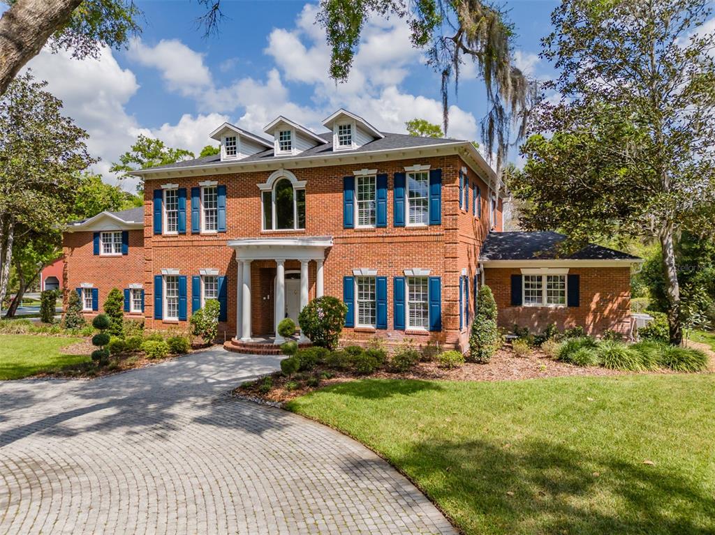 A two-story brick house with blue shutters, a circular driveway, and three roof dormers — 1816 S DOVER ROAD, DOVER, FL