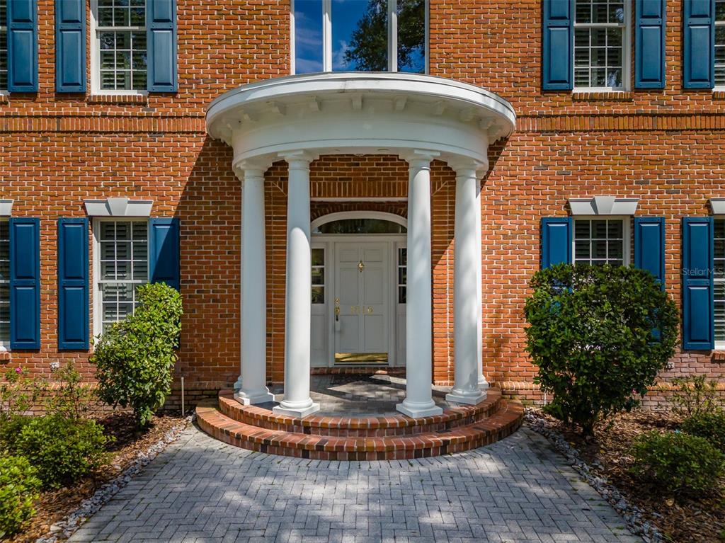 A red brick house features a white semi-circular portico with columns over the front entrance — 1816 S DOVER ROAD, DOVER, FL