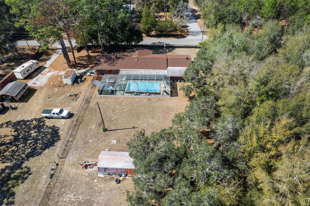 An aerial view shows a house with a screened pool, outbuildings, and a large yard — 265 S THAYER AVENUE, LECANTO, FL