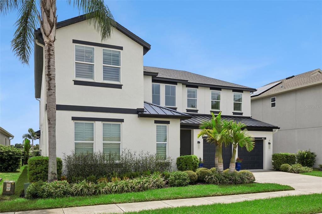 A screened-in swimming pool with a rock waterfall overlooks a lake with lounge chairs — 433 BLUE CYPRESS DRIVE, GROVELAND, FL