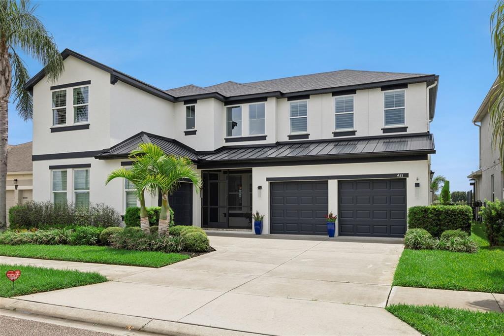 A dining room features a wooden table, upholstered chairs, wall paneling, and a large painting — 433 BLUE CYPRESS DRIVE, GROVELAND, FL