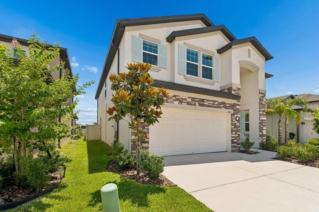 A two-story suburban house features a stucco exterior, stone accents, and a two-car garage — 16011 SONOMA GROVE CIRCLE, TAMPA, FL