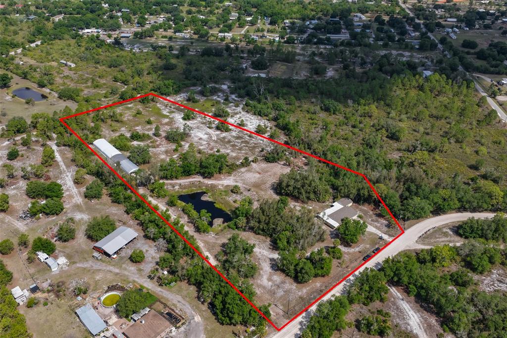 An aerial view shows a large, rural property outlined in red with a pond and structures — 14451 HIGHLAND ROAD, WIMAUMA, FL