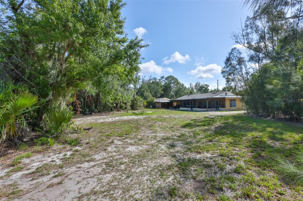 An aerial view shows a house and a detached structure on a large, wooded lot — 14451 HIGHLAND ROAD, WIMAUMA, FL
