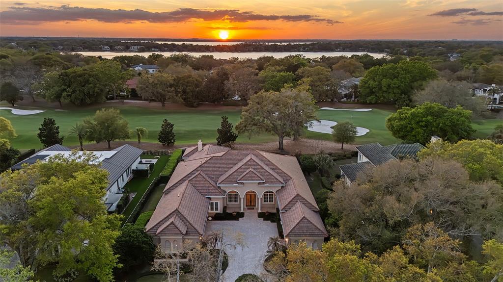 An aerial view shows a large house with a tiled roof overlooking a golf course — 5151 LATROBE DR, WINDERMERE, FL