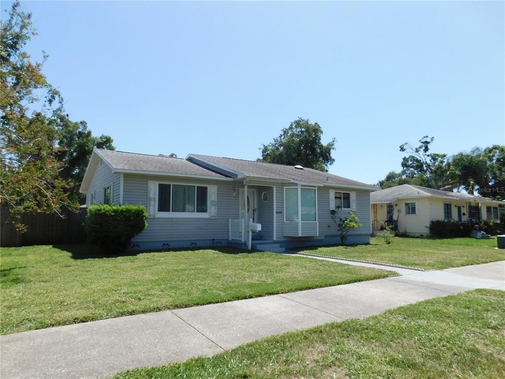 A single-story gray house with a bay window and a front lawn under a blue sky — 5430 2ND AVENUE N, ST PETERSBURG, FL