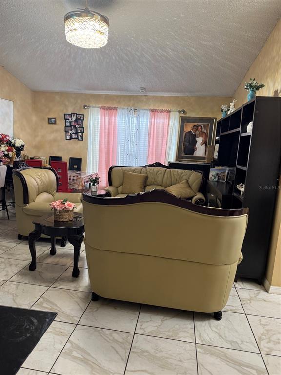 A living room features beige leather furniture, a dark wood bookshelf, and tile flooring — 3407 LAKE TINY CIRCLE, ORLANDO, FL