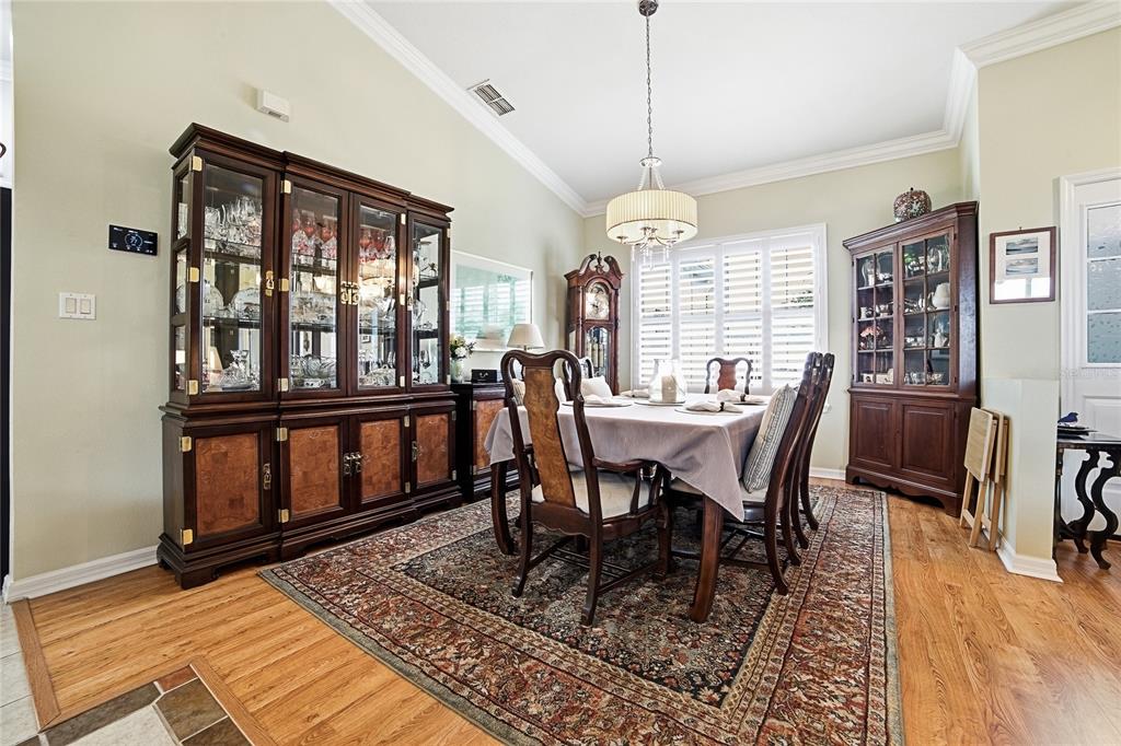 A dining room features a wooden hutch, a grandfather clock, and a table with chairs — 3550 HUNTSVILLE LANE, LEESBURG, FL