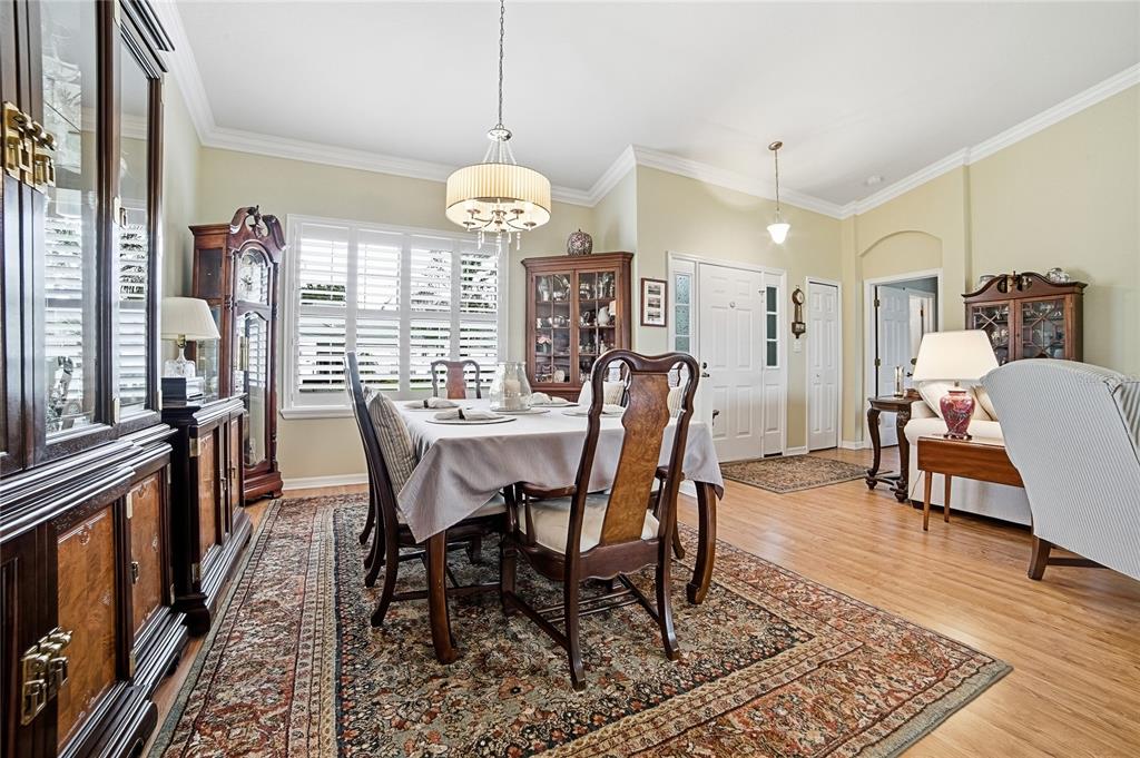 A dining room features a wooden table, chairs, a chandelier, and a large area rug — 3550 HUNTSVILLE LANE, LEESBURG, FL