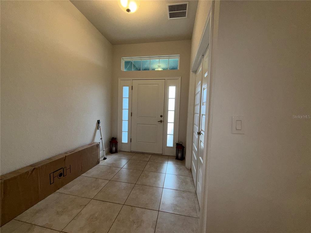 An entryway features tiled flooring, a white front door with sidelights, and a closed closet — 14921 TROPICAL VIOLET WAY, WIMAUMA, FL