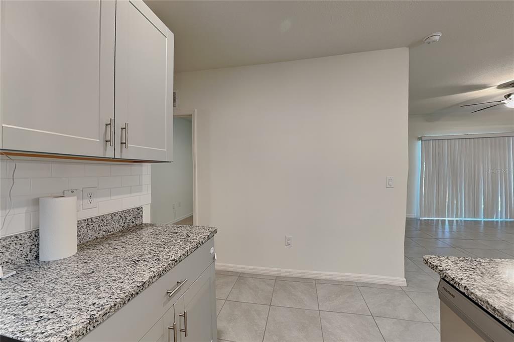 A kitchen with gray cabinets, granite countertops, and white subway tile backsplash — 230 MEGHAN CIRCLE, DELAND, FL