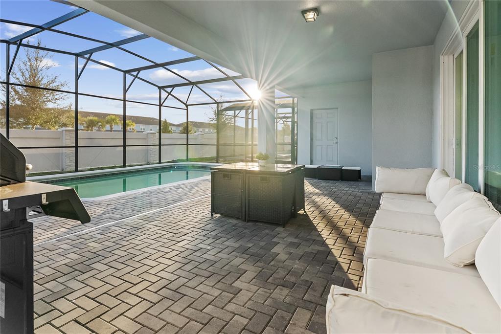 A covered patio features a swimming pool, brick pavers, and outdoor furniture — 16208 SAINT MARTIN STREET, CLERMONT, FL