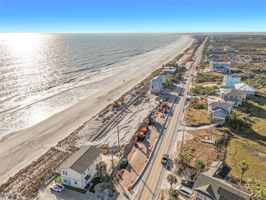 An aerial view shows a coastal road, beach, and construction site with heavy machinery — 3560 COASTAL HIGHWAY, ST AUGUSTINE, FL