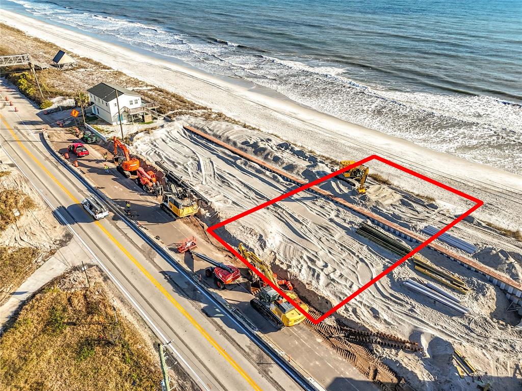 An aerial view shows construction equipment working on a sandy beach lot near a road — 3560 COASTAL HIGHWAY, ST AUGUSTINE, FL